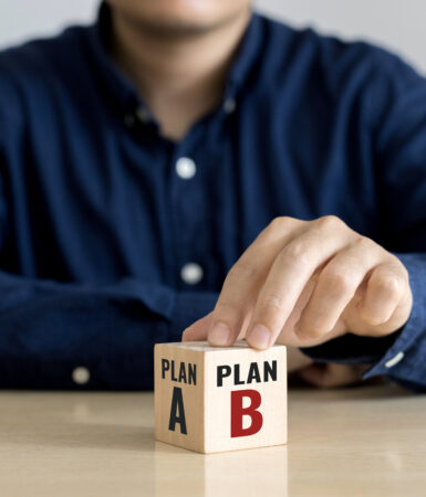 Mand sidder med en terning, hvor han kan vælge plan A eller plan B. Det skal illustrere beredskabsplan og dilemmaspillets muligheder for at vælge.